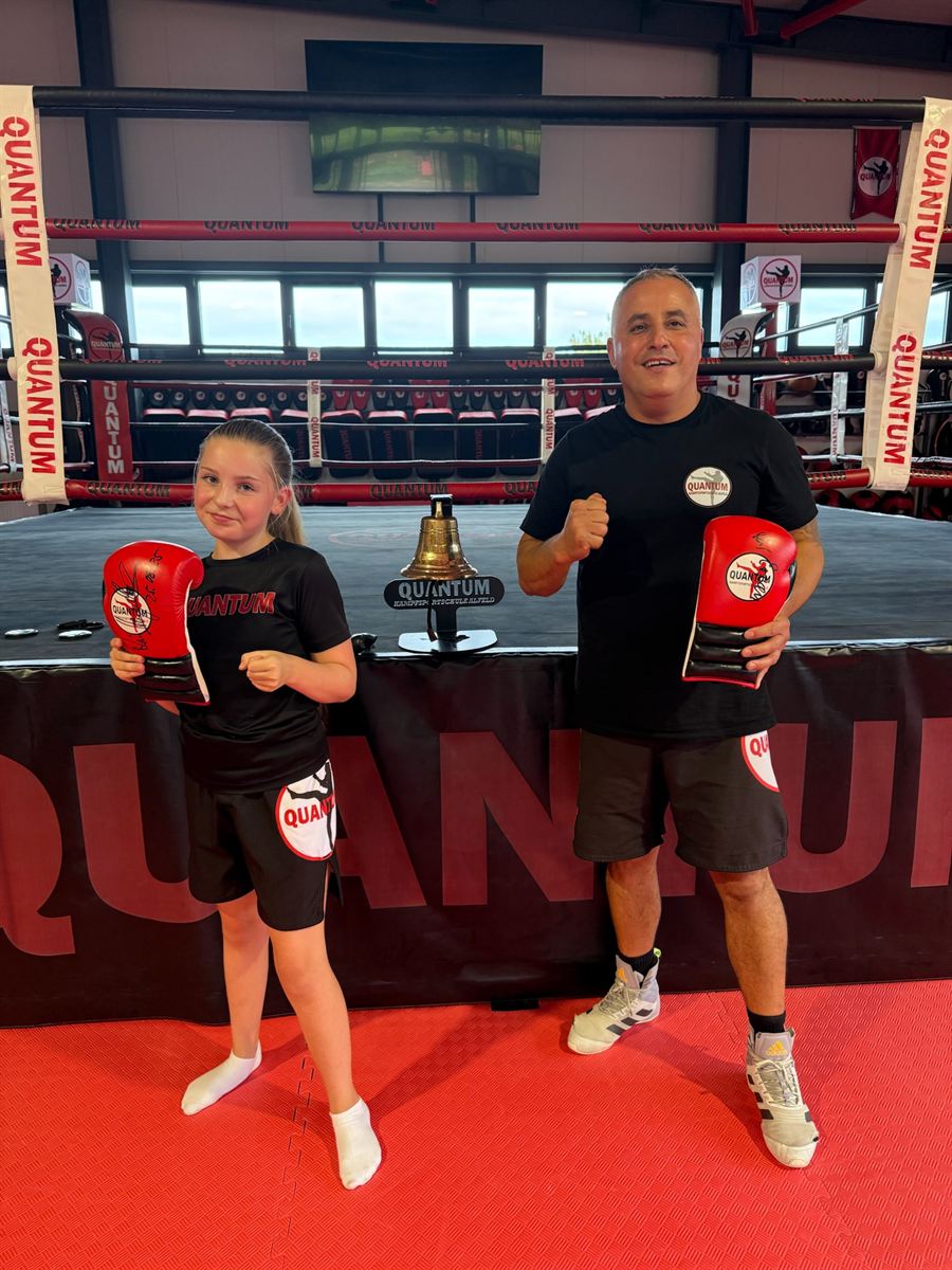 Trainer hält einem Kind die Pratzen im Ring