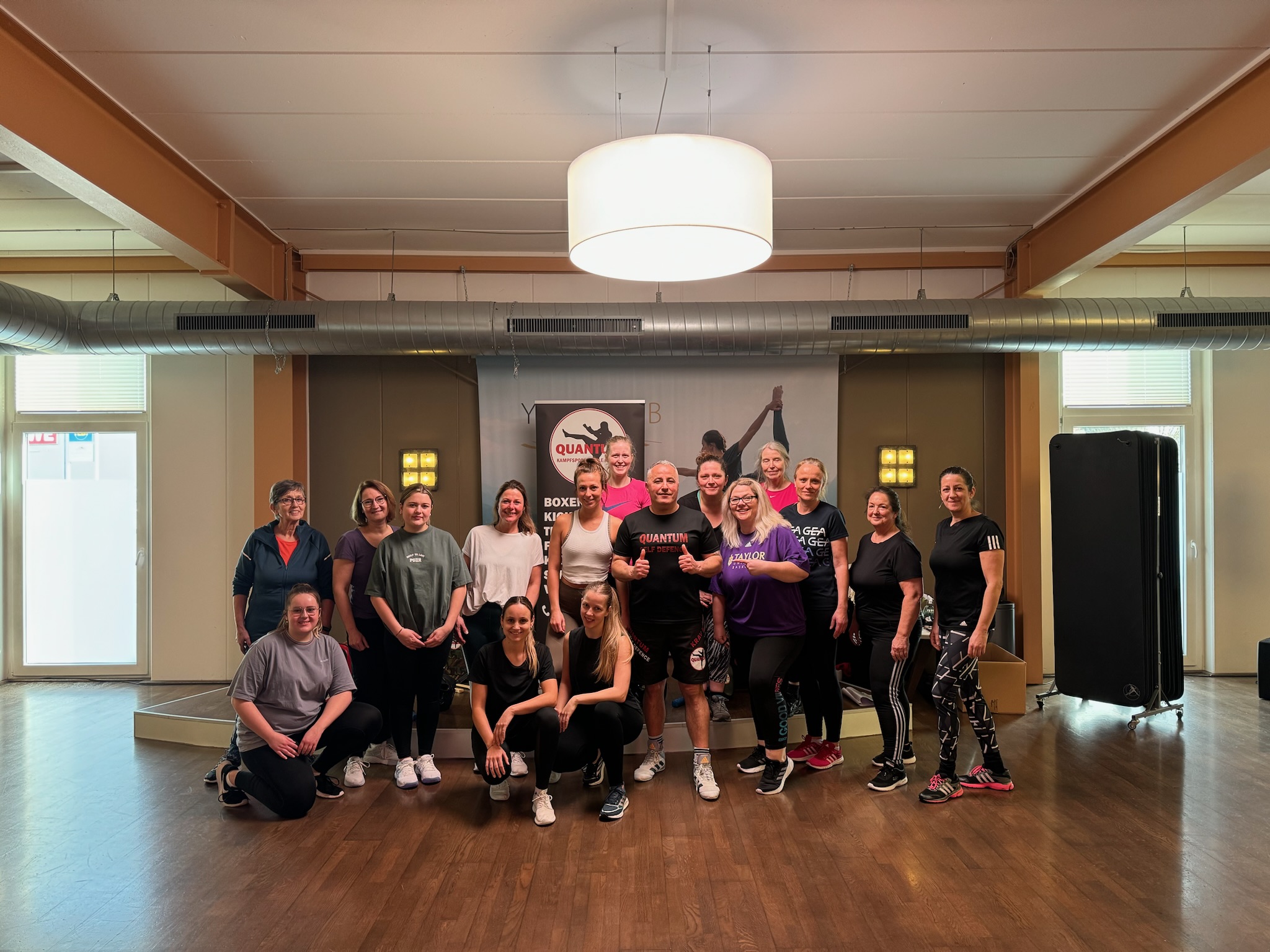 Teilnehmerinnen eines Selbstverteidigungskurses mit dem Coach